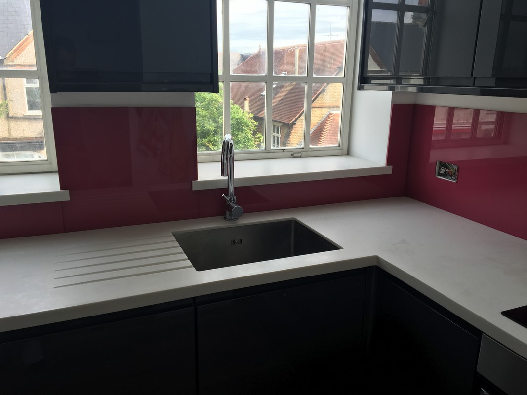 Deep plum coloured glass splashback in modern Whitechapel kitchen