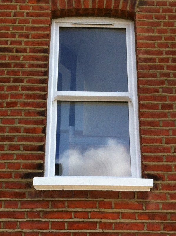 uPVC sash window on Victorian red brick house in Whitechapel
